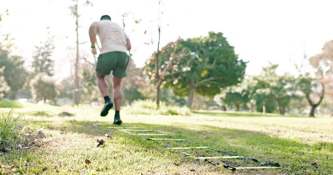 Park exercise, speed ladder and person doing outdoor nature workout, morning cardio drill or athlete exercise challenge. Back of agile runner doing active sports training on green grass field