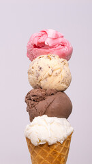 Coconut milk ice cream cones, chocolate, chocolate chips, and strawberries stacked on a white background.