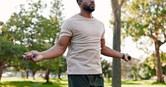 Outdoor, cardio and man skipping with a rope in park, forest or healthy fitness training in nature with exercise equipment. Athlete, jumping and workout warmup in morning for cardiovascular wellness