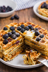 Stack of Belgian blueberry waffles cut with fork