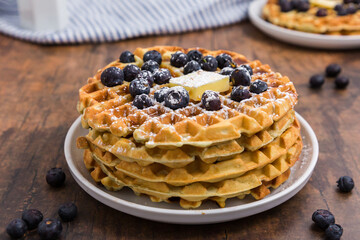 Stack of Belgian blueberry waffles with butter