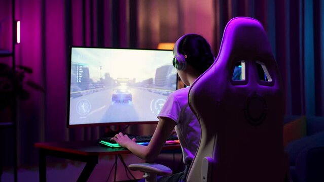 Excited Asian Teen Girl Gamer Celebrates Victory While Playing Video Game On Computer, Playing A Racing Video Game
