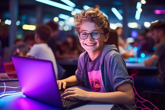 Portrait of smiling boy using laptop in gaming club at night time