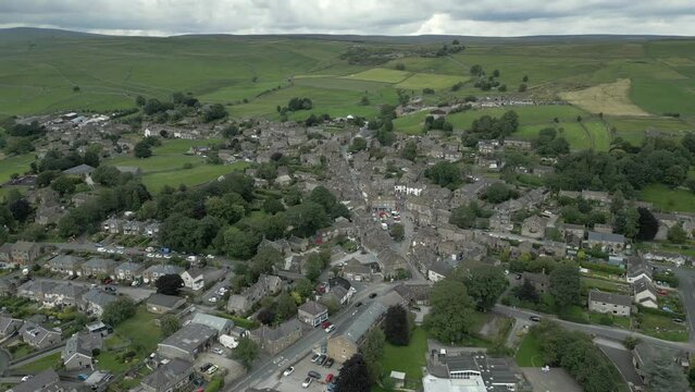 An aerial view of the Yorkshire town of Grassington on a cloudy summer afternoon, England, UK. Circling left to right around the town centre.