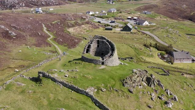 Drone shot circumnavigating the 'Dun Carloway Broch' on the west coast of the Isle of Lewis, part of the Outer Hebrides of Scotland. The broch is a tourist attraction first built around 100AD.