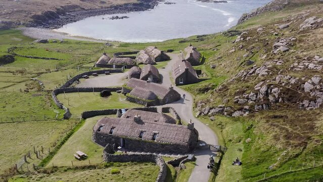 Tilting drone shot of the Gearrannan Blackhouse Village on the Isle of Lewis, part of the Outer Hebrides of Scotland. A blackhouse is a traditional type of house which used to be common in Scotland.