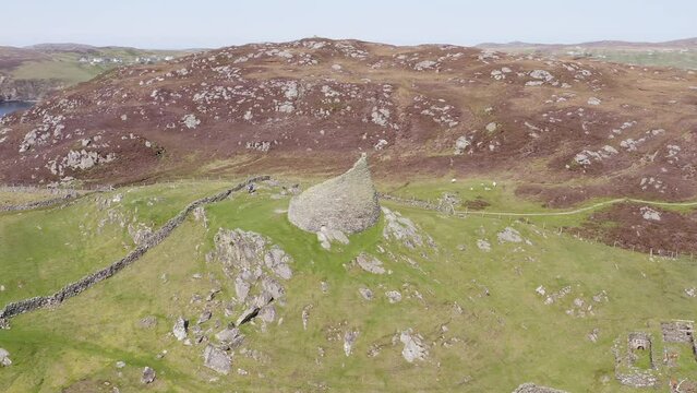 Dynamic drone shot of the 'Dun Carloway Broch' on the west coast of the Isle of Lewis, part of the Outer Hebrides of Scotland. The broch is a tourist attraction first built around 100AD.