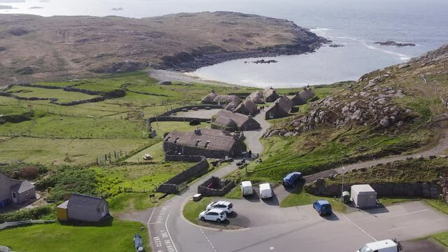 Advancing drone shot of the Gearrannan Blackhouse Village on the Isle of Lewis, part of the Outer Hebrides of Scotland. A blackhouse is a traditional type of house which used to be common in Scotland.