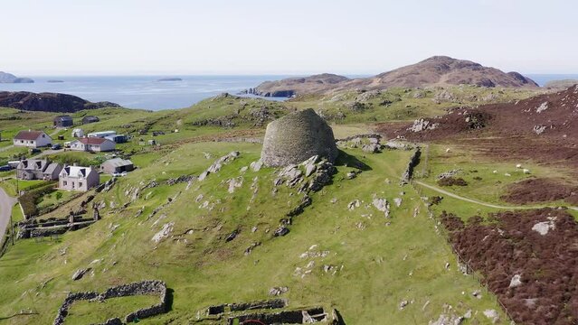 Tilting drone shot of the 'Dun Carloway Broch' on the west coast of the Isle of Lewis, part of the Outer Hebrides of Scotland. The broch is a tourist attraction first built around 100AD.