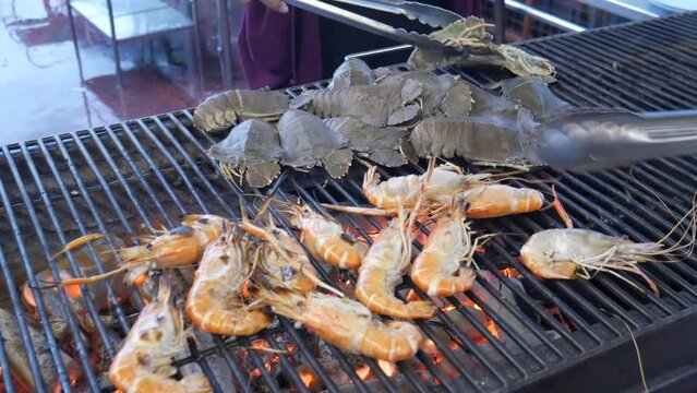 grill cooking slipper lobster and river prawn on hot charcoal in thailand seafood restaurant