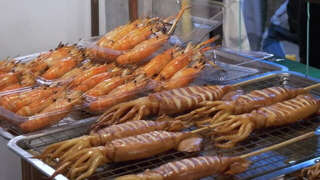 thailand night market street food booth squid and river prawn cooked ready to serve