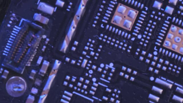 Computer motherboard components. PC chip close up, tracking shot. Microchips top view flashing neon light, CPU processor. 
