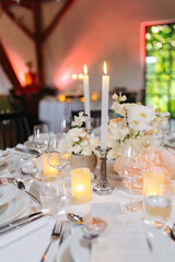 Beautiful table setting and decorations at a wedding. Wedding venue with beautiful decor, flowers, cutlery and lights