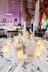 Beautiful table setting and decorations at a wedding. Wedding venue with beautiful decor, flowers, cutlery and lights