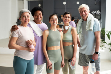 Portrait of fitness instructor smiling at camera together with her group after training