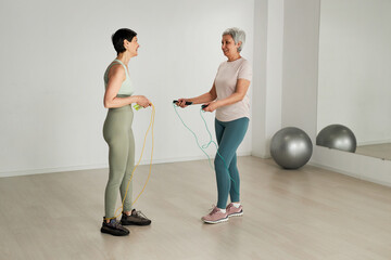 Obraz premium Mature women jumping on skipping rope in health club