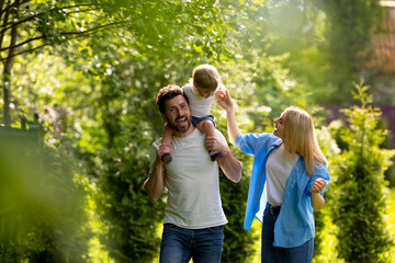 Fototapeta premium Parents and their cure kid spending time in the park