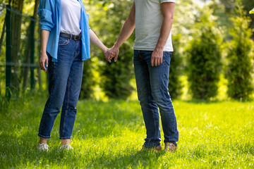 Couple holding hands and having a walk in the park