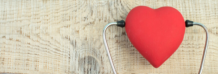 Red heart and a stethoscope on desk. Scientific medical research concept. panorama, banner.