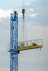 disassembly of construction cranes using a lifting arm, worker on top of Metal struture
