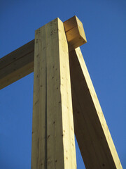 large and sturdy wooden structure, detail against a blue sky background
