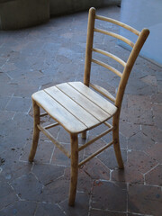 light rough wooden chair on an old terracotta floor

