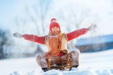 Hello winter concept! Funny little child runs on sledge in snow. Active sports games in winter time.