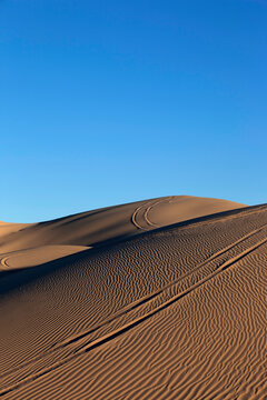 San dunes with wheel ruts and patterns vertical