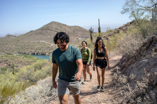 Hikers on desert mountain trail on sunny day