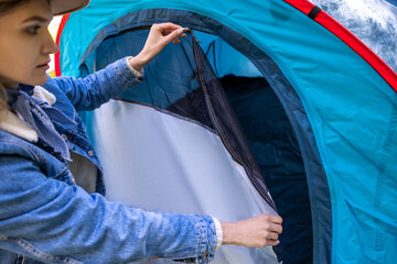 Blonde woman closing the entrance to the tent