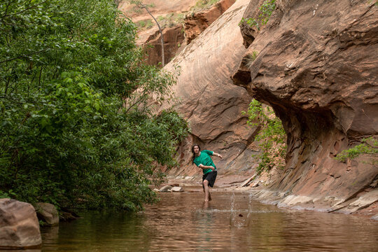 Young man skips stones in creek