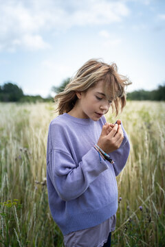 Young Girl Looking at Lady Bug in a Beautiful Field in Denmark