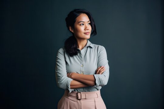 Smiling Asian businesswoman posing thoughtfully against grey background. Photo generative AI