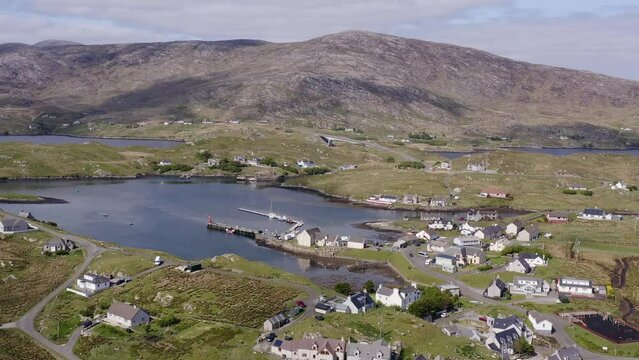 Drone shot circling the village on the Isle of Scalpay, an island near the Isles of Harris and Lewis on the Outer Hebrides of Scotland. The town of Tarbert is revealed in the background.