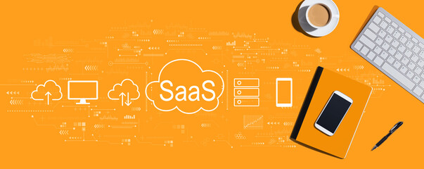 Naklejka premium SaaS - software as a service concept with a computer keyboard and office items