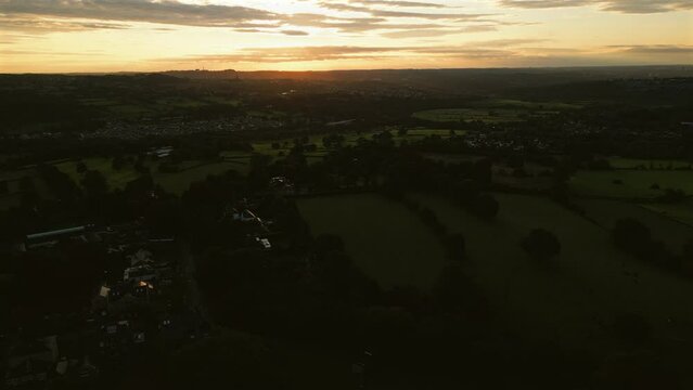 Establishing Drone Shot Over Fields and Houses at Sunrise