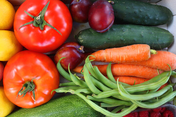 Wooden crate full of healthy colorful seasonal fruit and vegetable. Top view.