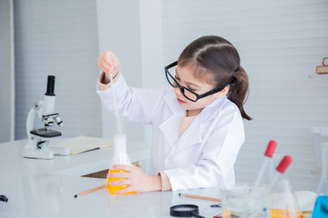 Adorable kindergarten school little girl student wearing lab coats happy studying dropping chemical...