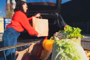 woman put packages in car trunk