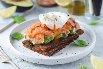 A rye bread sandwich with avocado and salmon	