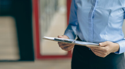 Female accountant holding clipboard isolated on blurred background Close-up pictures
