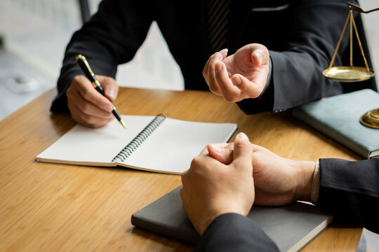 Businessman and lawyer discussing contract documents sitting at table Legal concepts, advice, close-up pictures