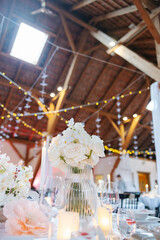 Beautiful table setting and decorations at a wedding. Wedding venue with beautiful decor, flowers, cutlery and lights