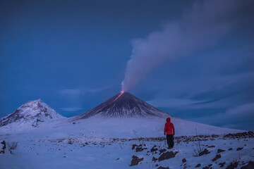 A traveler near the erupting volcano Klyuchevskaya Sopka