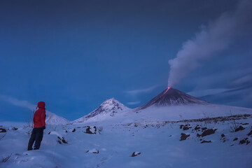 A traveler near the erupting volcano Klyuchevskaya Sopka