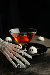 A cocktail with an eye inside on a festive table for Halloween