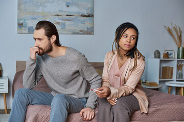 abortion concept, man and african american woman with pregnancy test, stressed couple, tense