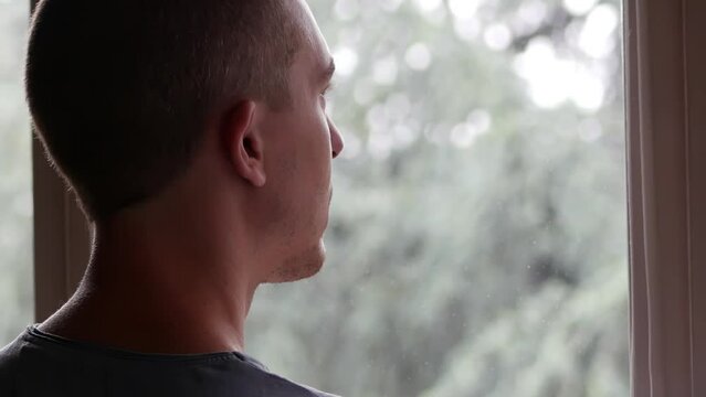 A Sad Man Thinking while Looking at the Rain from the Window