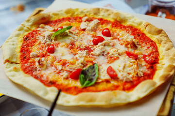 Delicious pizza on thin dough on the table.
