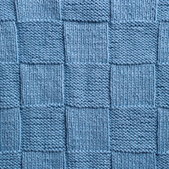 Unusual abstract blue knitted chess pattern background texture. Top view of knitting clothes